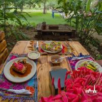 Una mesa de madera con platos de comida encima. en HACIENDA SANTO DOMINGO DE YUNKU, en Yuncu