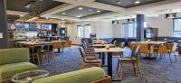 Un restaurante con mesas y sillas y un bar. en Courtyard by Marriott Anchorage Airport, en Anchorage
