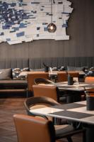 a dining room with tables and chairs and a large painting at AC Hotel by Marriott Chengdu North in Chengdu