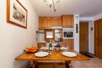 a kitchen with a wooden table with a bowl of fruit at Appartement Les Capucins 22 - Happy Rentals in Chamonix