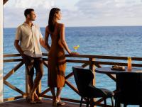 Un hombre y una mujer de pie en un balcón con vistas al océano. en Mercure Maldives Kooddoo - Adults-Only Escape - 50 percent off Domestic Transfers, en Gaafu Alifu Atoll