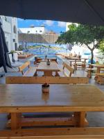 un grupo de mesas de picnic de madera con sombrilla en Oceanis Resort, en Parikia