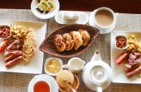 Una mesa cubierta con platos de comida y tazas de té. en Alama Camp Mara, en Ololaimutiek
