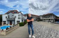 un hombre parado frente a una casa en Brill Hotel Békéscsaba, en Békéscsaba