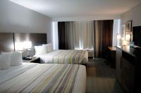 ein Hotelzimmer mit zwei Betten und einem Schreibtisch in der Unterkunft Country Inn &amp; Suites by Radisson, Council Bluffs, IA in Council Bluffs