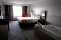 ein Hotelzimmer mit einem Bett und einer Badewanne in der Unterkunft Country Inn &amp; Suites by Radisson, Council Bluffs, IA in Council Bluffs