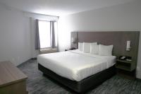ein Hotelzimmer mit einem großen Bett mit weißen Laken in der Unterkunft Country Inn &amp; Suites by Radisson, Council Bluffs, IA in Council Bluffs