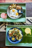 Dos platos de comida con huevos y verduras en una mesa. en Jamboree Creek Yoga, en North goa