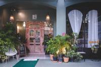 uma frente de loja com plantas e uma porta de madeira em Blu Monkey Boutique Phuket Town em Cidade Phuket