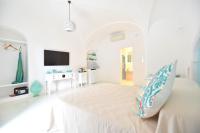 a white room with a bed and a tv at Casa Mulini in Positano