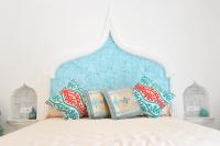 a bed with a blue headboard with pillows on it at Casa Mulini in Positano