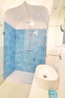 a bathroom with a blue tiled shower and a toilet at Casa Mulini in Positano