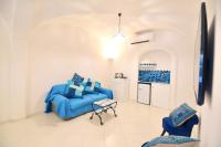 a living room with a blue couch and two chairs at Casa Mulini in Positano