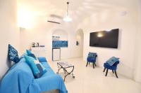 a living room with a blue couch and chairs at Casa Mulini in Positano