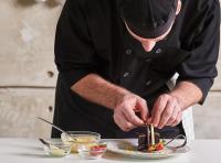 布赖代منازل البندقية BQ hotel suites的桌上准备一盘食物的人