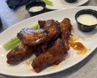 a plate of food with chicken wings and celery at Cambria Hotel Rehoboth Beach in Rehoboth Beach