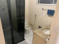 a bathroom with a toilet and a shower and a sink at Casarão Hostel in Guaratinguetá