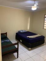 a bedroom with two beds and a ceiling fan at Casarão Hostel in Guaratinguetá