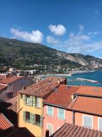 a view of a city with houses and the water at Duplex vue mer 50m de la plage des Sablettes in Menton