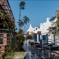 un patio al aire libre con mesas, sillas y edificios en Ios Hotel & Village Extension, en El Alamein