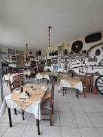 a restaurant with tables and chairs in a room at 75 Steps Apartments in Mesongi