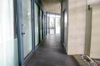an empty hallway in an office building with glass doors at Berger Zentrum in Berg
