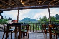 a balcony with tables and chairs and a view of a mountain at O2 Villas Ella in Ella