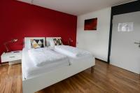 a bedroom with a red wall and two beds at Berger Zentrum in Berg