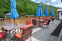 una terraza con mesas, sillas y sombrillas azules en Clear River Inn and Tavern, en Pittsfield