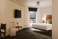 ein Hotelzimmer mit einem Bett und einem Koffer in der Unterkunft FOUND Hotel, Santa Monica in Los Angeles