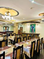 廷布Hotel Migmar的一间摆着桌椅、墙上挂着一幅画的餐厅