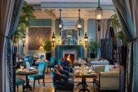 a dining room with tables and chairs and a fireplace at Palais Ronsard Relais & Chateaux in Marrakech