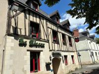 un edificio con puertas rojas y ventanas en una calle en Hôtel Le Blason, en Amboise