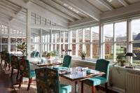a restaurant with tables and chairs and windows at The Devonshire Arms Hotel at Bolton Abbey in Bolton Abbey