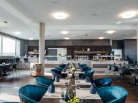 カールスルーエにあるMEET EAT SLEEP das Konferenzzentrum in Karlsruheの青い椅子とテーブル、キッチン付きのレストラン