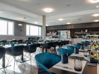 カールスルーエにあるMEET EAT SLEEP das Konferenzzentrum in Karlsruheの青い椅子とバーのあるレストラン