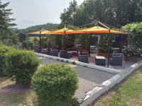 ein Garten mit Sitzbereich und Sonnenschirm in der Unterkunft CAMPING LA PERLE in La Rochette