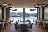 een restaurant met tafels en stoelen en een groot raam bij NEYA Porto Hotel in Porto
