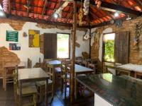 ein Restaurant mit Tischen und Stühlen in einem Raum in der Unterkunft Pousada e Restaurante Casinha Velha in Macacos