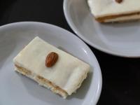 Hotel Verona Villa de Leyva في فيلا دي ليفا: قطعة كعكة مع حبة جوز على طبق