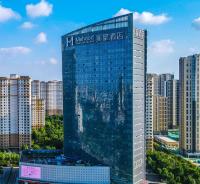 Un edificio alto con un cartel en una ciudad. en Mehood Theater Hotel, Jining High -tech Zone, en Jining