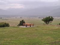 a picnic table on a hill in a field at Apartman ANA in Vrlika