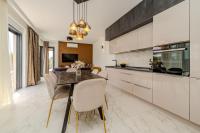 a kitchen and dining room with a table and chairs at Villa Rosa with a heated pool in Privlaka