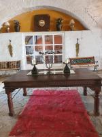 a wooden table in a room with a red rug at Hotel Rural El Vaqueril in Navas del Madroño