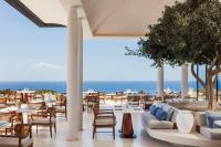 Un restaurante con mesas y sillas y el océano. en One&Only Kéa Island, en Pisses