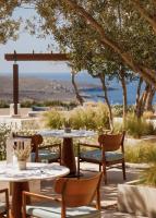 Un patio con mesas y sillas y vista al mar. en One&Only Kéa Island, en Pisses