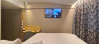 a room with a bed and a tv on the wall at Geographotel Paris-Roissy CDG Airport in Le Mesnil-Amelot