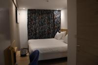 a hotel room with a bed with a curtain at Geographotel Paris-Roissy CDG Airport in Le Mesnil-Amelot