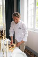 Een man in een keuken die eten klaarmaakt op een tafel. bij Château de Taradel in Taradeau
