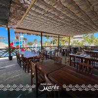 a restaurant with tables and chairs and a view of the beach at Hotel das Marés in Trairi